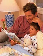 父亲在睡前听儿子读书的画面
