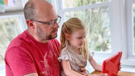 父亲和女儿分享平板电脑屏幕